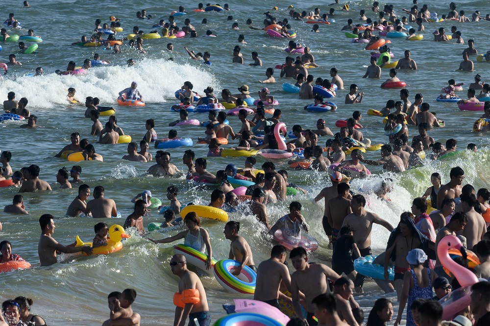 People cool themselves on a beach in Qingdao, eastern China’s Shandong province on August 3, 2019. — AFP pic         