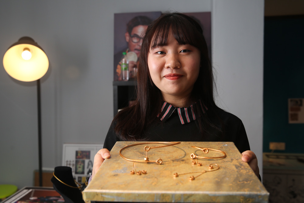 Ester Haw Jing Rong posing with her unique hexagonal nut-inspired fashion accessory designs. u00e2u20acu201d Picture by Choo Choy May