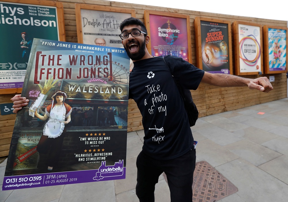 A man holding a poster is seen in front of flyers advertising shows at the Fringe in Edinburgh, Scotland August 1, 2019. u00e2u20acu201d Reuters pic