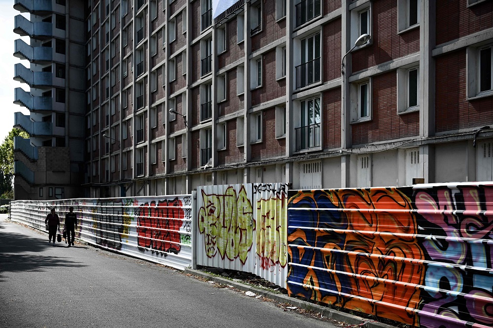 People walk past a red brick building of the Youri Gagarine quarter in Ivry-sur-Seine, on the outskirts of the French capital Paris August 19, 2019. — AFP pic 
