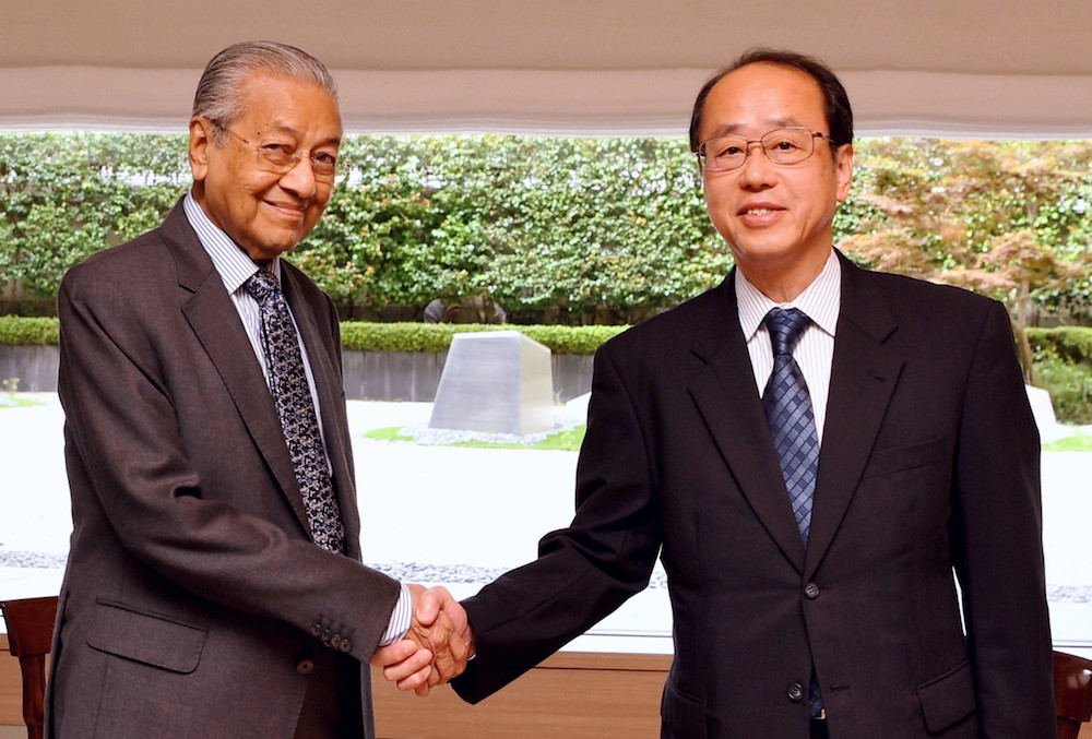 Prime Minister Tun Dr Mahathir Mohamad shakes hands with special adviser to the Japanese prime minister, Hiroto Izumi, in Fukuoka August 8, 2019. u00e2u20acu201d Bernama pic