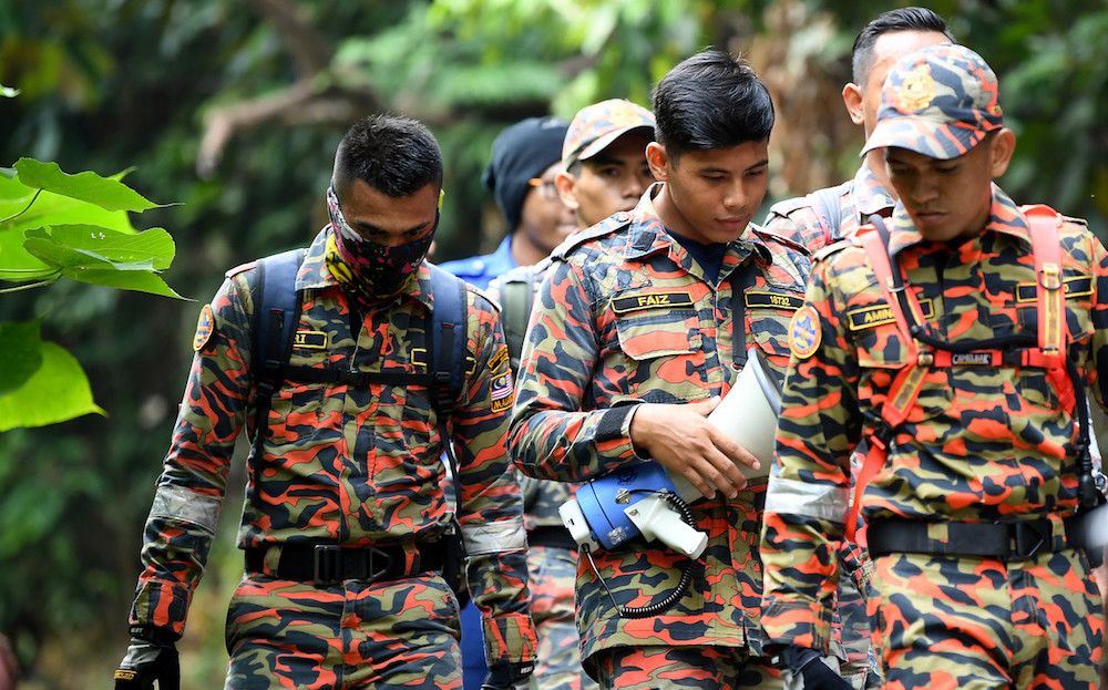 A rescuer holds a bullhorn while participating in the search for missing Irish teen Nora Anne Quoirin in the jungle near Seremban August 9, 2019. — Bernama pic
