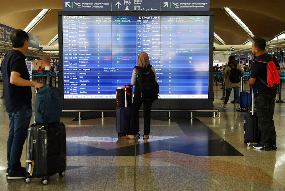Passengers check their flight information at KLIA in Sepang August 22, 2019, during a systems outage. — Bernama pic