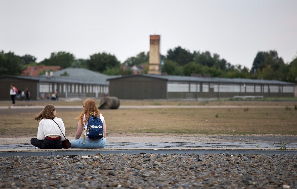 Visitors sit next to a steel frame filled with rocks marking the outline of barrack 14 at the former concentration camp in Oranienburg, eastern Germany August 7, 2019. — AFP pic