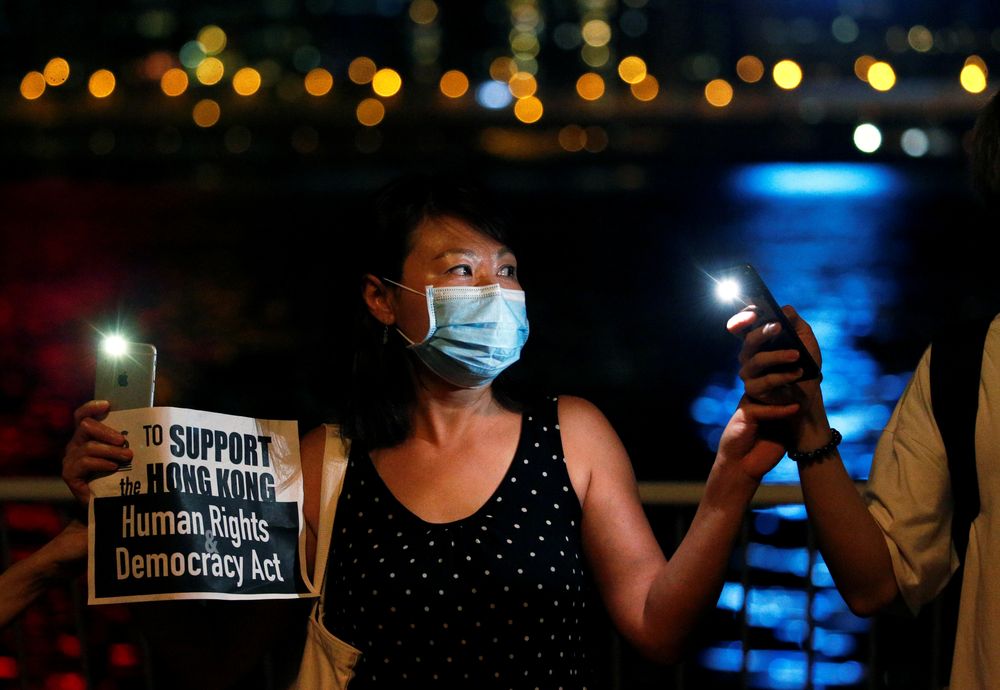 A woman holds a placard as protesters hold hands to form a human chain during a rally to call for political reforms at Tsim Sha Tsui and Hung Hom Promenade in Hong Kong, China, August 23, 2019. u00e2u20acu201d Reuters pic