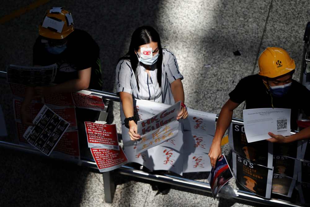 Anti-extradition Bill demonstrators try to distribute leaflets to passengers during a protest at the Hong Kong International Airport, August 13, 2019. u00e2u20acu2022 Reuters pic