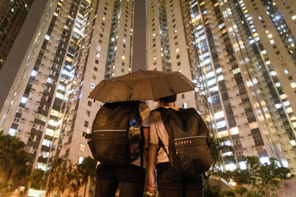 In this picture taken on August 25, 2019, Abby, 19, and her boyfriend Nick, 20, pose in front of residential buildings after they attended a protest in Tsuen Wan, an area in the New Territories in Hong Kong. — AFP pic