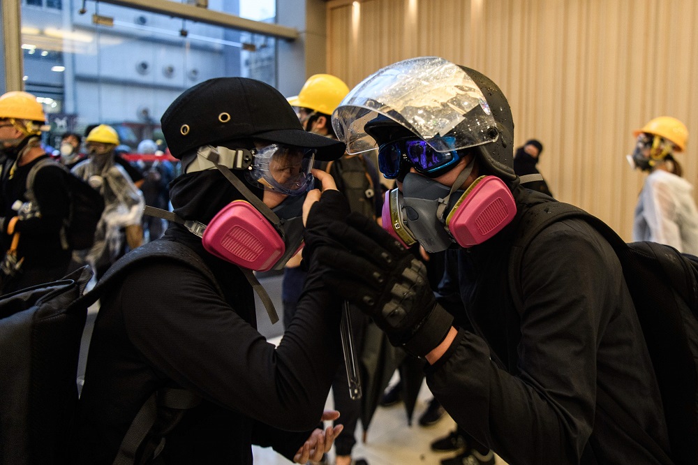 In this picture taken on August 25, 2019, Abby (left), 19, and her boyfriend Nick, 20, speak through their gas masks after they found each following their separation, as tear gas was fired by police during a protest in Tsuen Wan, Hong Kong. u00e2u20acu201d AFP pic