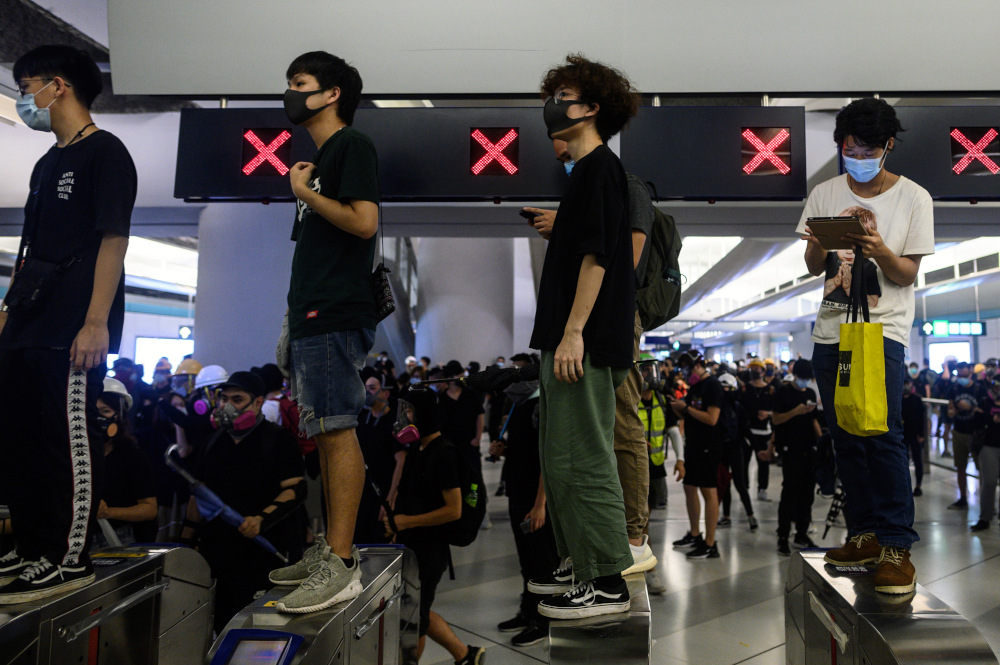 Protesters stand on a turnstile at the Yuen Long MTR station in Hong Kong during a protest August 21, 2019. u00e2u20acu201d AFP pic 