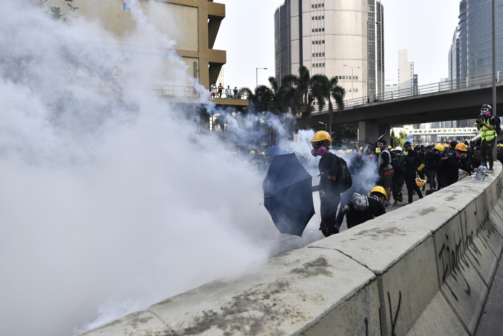 Protesters react to tear gas fired by police at Kowloon Bay in Hong Kong August 24, 2019, as demonstrators gather in the latest opposition to a planned extradition law that has since morphed into a wider call for democratic rights in the semi-autonomous c