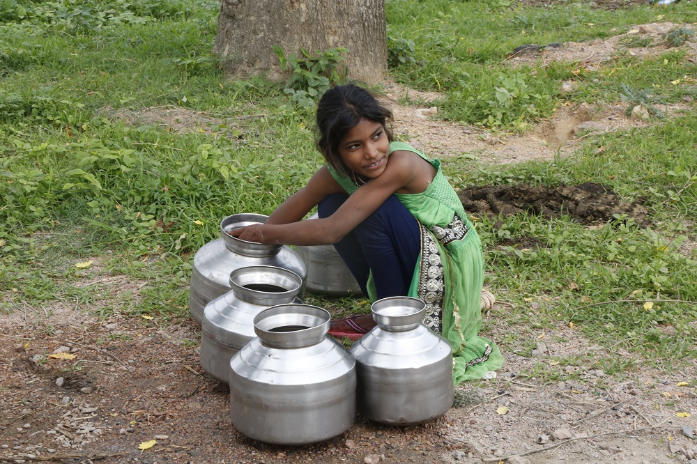A girl cleans her metal water pots in Bundelkhand, India July 16, 2019. u00e2u20acu201d Thomson Reuters Foundation pic