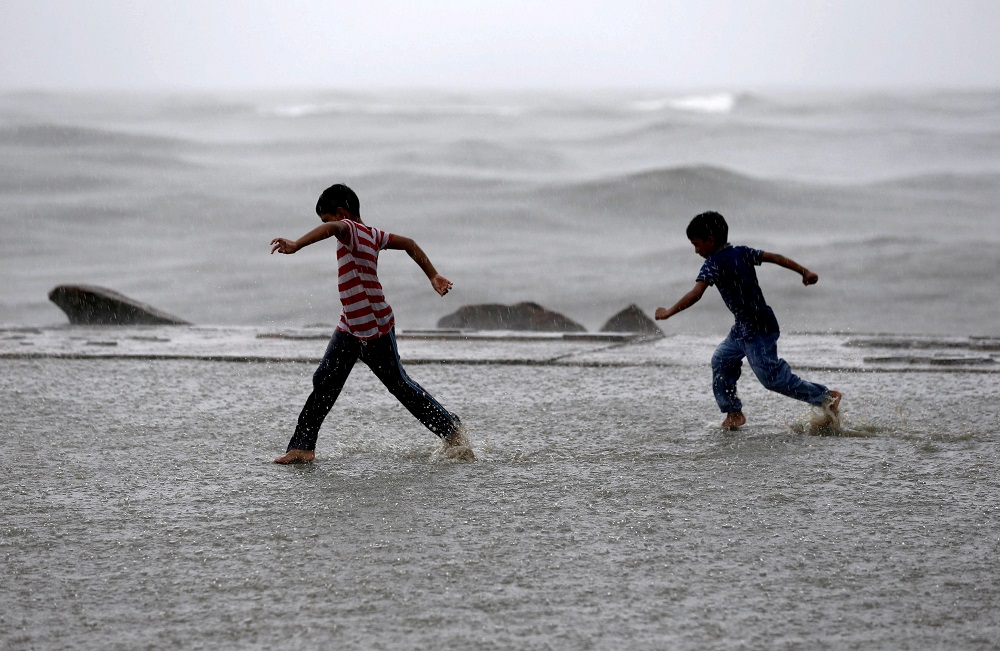Children play in a puddle of water as it rains at a sea front in Kochi, India, June 9, 2019. u00e2u20acu201d Reuters pic