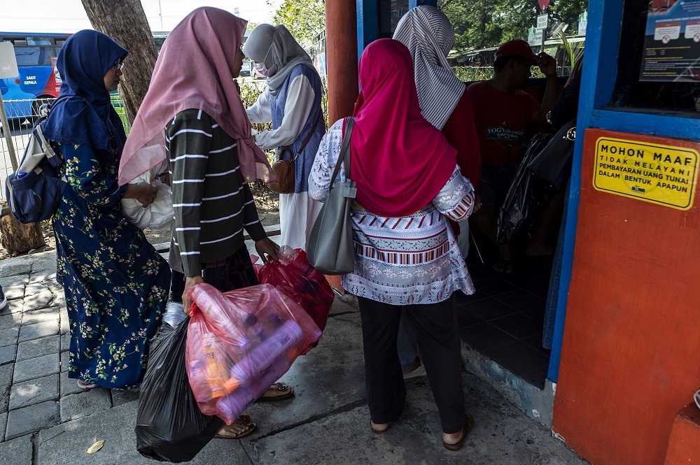 This picture taken on July 21, 2019 shows passengers exchanging plastic bottles for Suroboyo bus tickets at a terminal in the Indonesian city of Surabaya. — AFP pic
