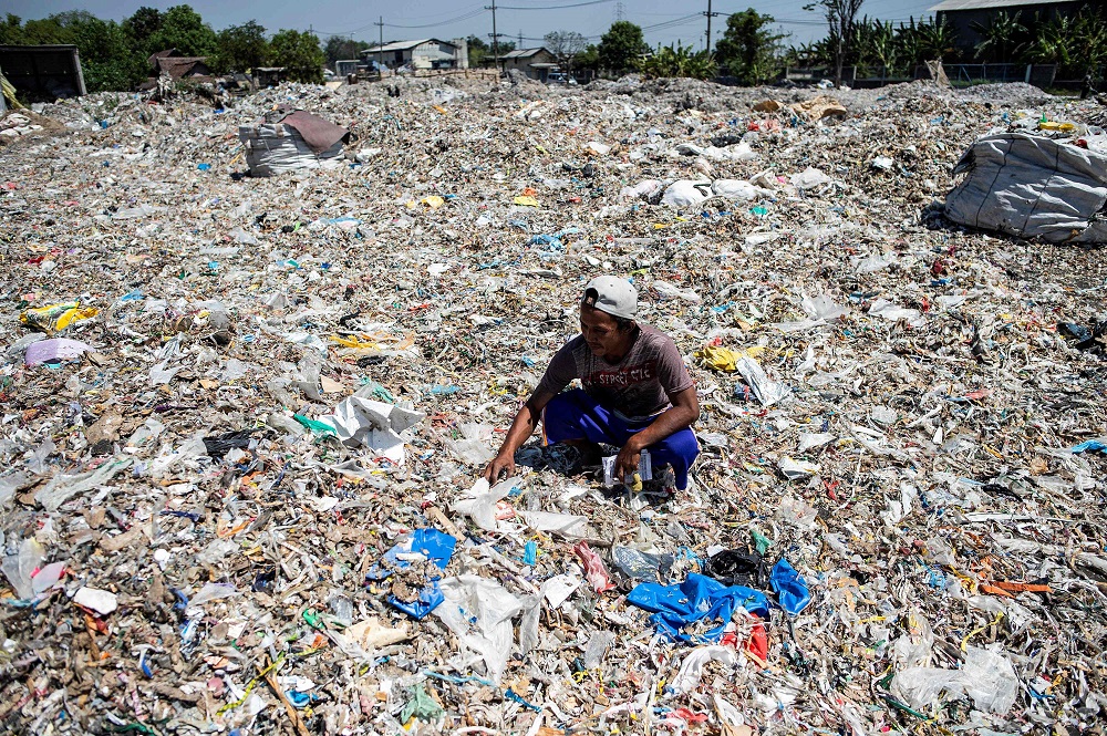 This picture taken on July 22, 2019 shows villager Keman sifting through plastic waste in the village of Bangun. u00e2u20acu201d AFP pic 