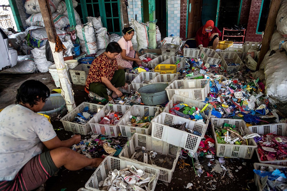 This picture taken on July 22, 2019 shows villagers sifting through plastic waste in the village of Bangun. — AFP pic