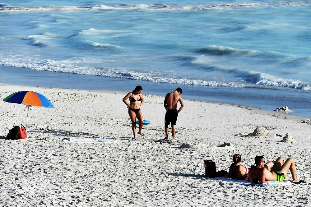 Tourists sunbathe on the ‘Spiagge Bianche’ (white sand) beach in Rosignano Solvay, a town in Italy’s central Tuscany region July 31, 2019. — AFP pic