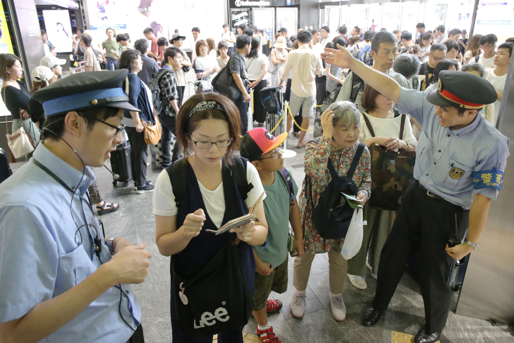 Railway employees assist stranded passengers at the Hakata Shinkansen station in the city of Fukuoka August 14, 2019. u00e2u20acu201d AFP pic