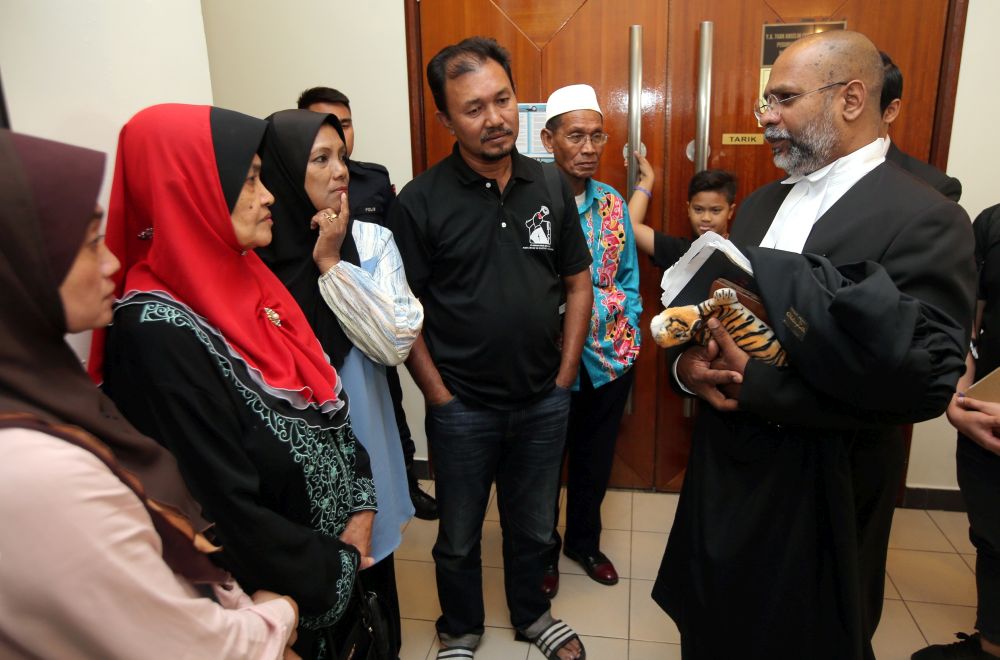 Kamarulnizam Ismailu00e2u20acu2122s family speak to their lawyer M. Visvanathan at the Ipoh High Court August 8, 2019. u00e2u20acu201d Picture by Farhan Najib
