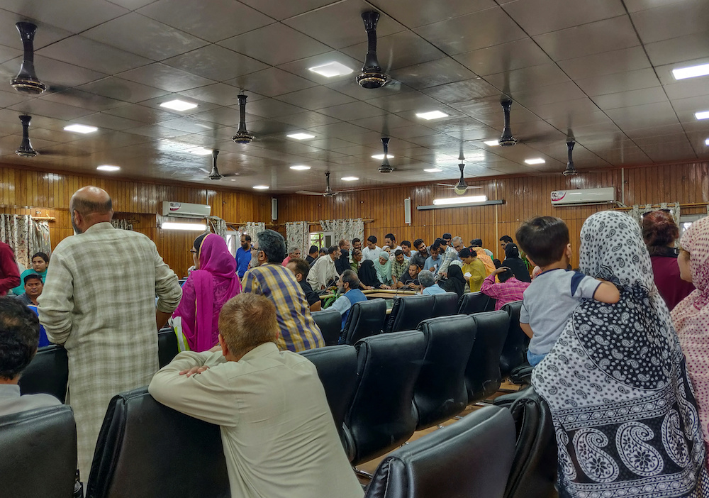 Kashmiris crowd around an official to use a phone at a government office, during restrictions after the scrapping of the special constitutional status for Kashmir by the government, in Srinagar August 10, 2019. u00e2u20acu201d Reuters