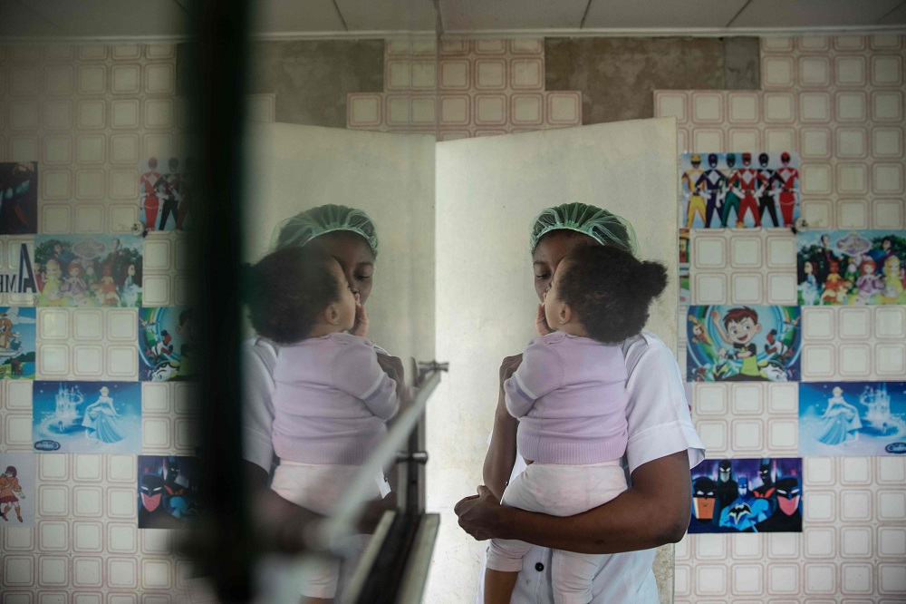 A young woman returning from Libya holds her baby at a vocational training centre in Benin City on June 27, 2019, opened by the Edo State to provide young returnees with the necessary training to start a new life. u00e2u20acu201d AFP pic  