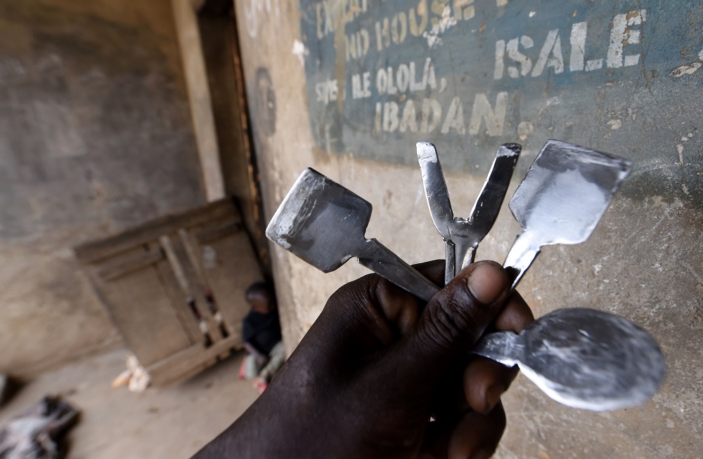 A man holds native instruments for tribal markings at the family compound of the Oloola Descendant Association, traditional practitioners of tribal markings in Ibadan, southwest Nigeria July 1, 2019. — AFP pic        