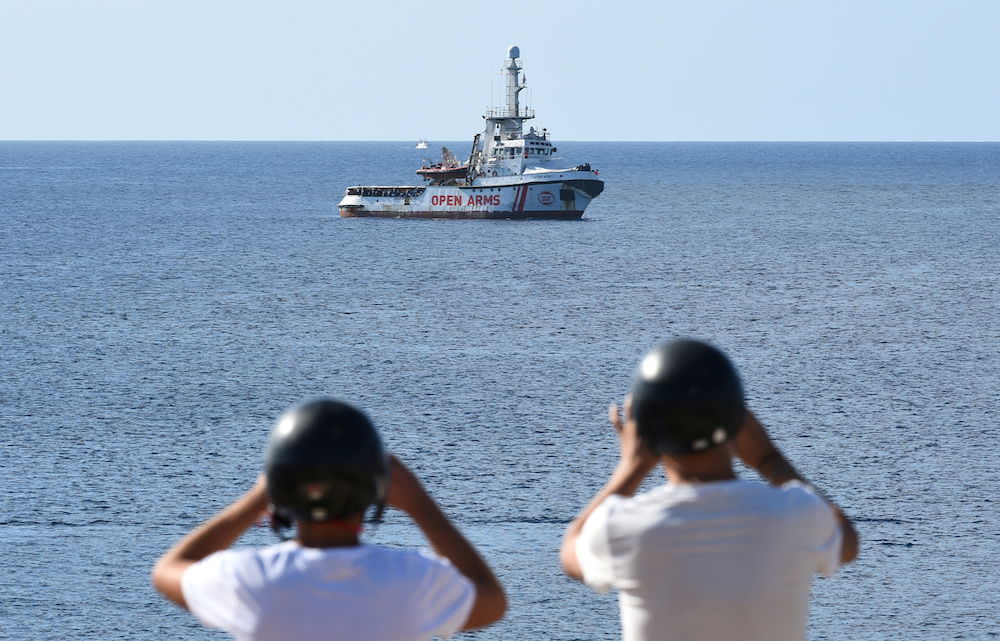 Tourists take pictures of the Spanish migrant rescue ship Open Arms close to the Italian shore in Lampedusa, Italy August 17, 2019. u00e2u20acu201d Reuters picn n