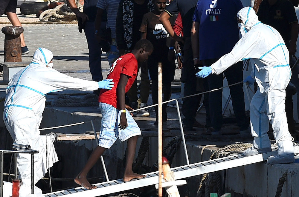 A minor who was among migrants stranded on the Spanish migrant rescue ship Open Arms disembarks in Lampedusa, Italy August 17, 2019. u00e2u20acu201d Reuters picn n