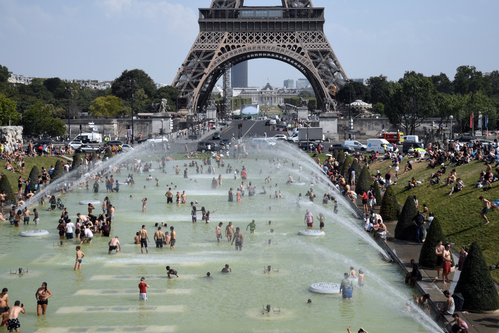 People cool off and sunbathe at the Trocadero Fountains in Paris, July 25, 2019 as a new heatwave hits the French capital. u00e2u20acu201d AFP pic