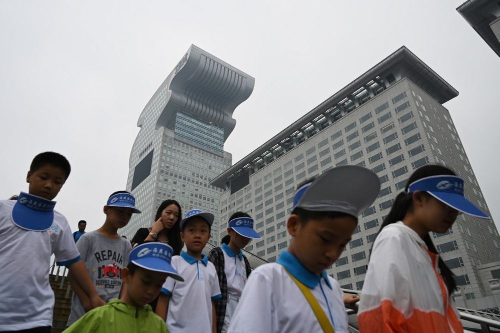 Children walk past Pangu Plaza, a skyscraper which dominates the area next to the Birdu00e2u20acu2122s Nest Olympic stadium, in Beijing on August 20, 2019. u00e2u20acu201d AFP pic