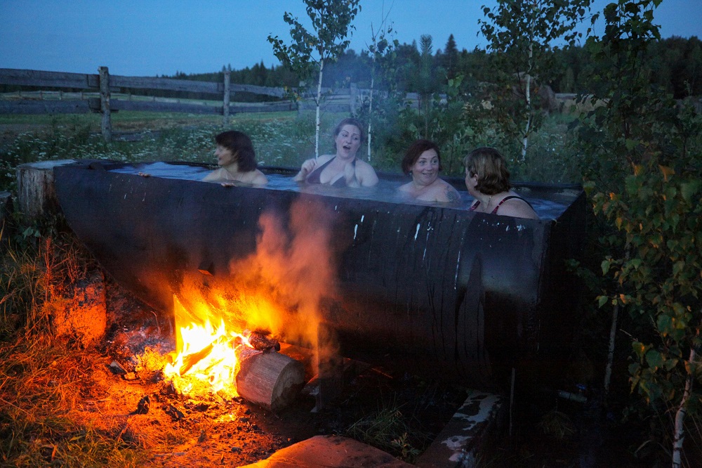 Latvian women bath in a huge tub heated by a bonfire in the village of Bobrovka, some 350km of Omsk July 31, 2019. — AFP pic