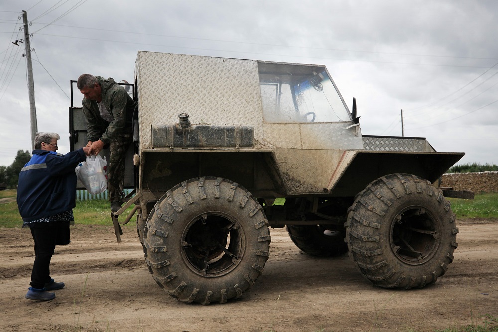 Postwoman Galina Yermolova gets on her homemade off-road vehicle as her husband helps her, in the village of Pikhtovskiy, Russia August 3, 2019. u00e2u20acu2022 AFP pic u00e2u20acu2022 AFP pic               