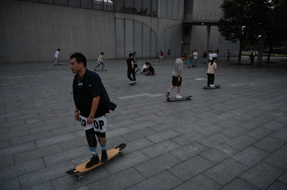 This photo taken on July 14, 2019 shows young people skateboarding next to the Shanghai Long Museum in Shanghai. — AFP pic        