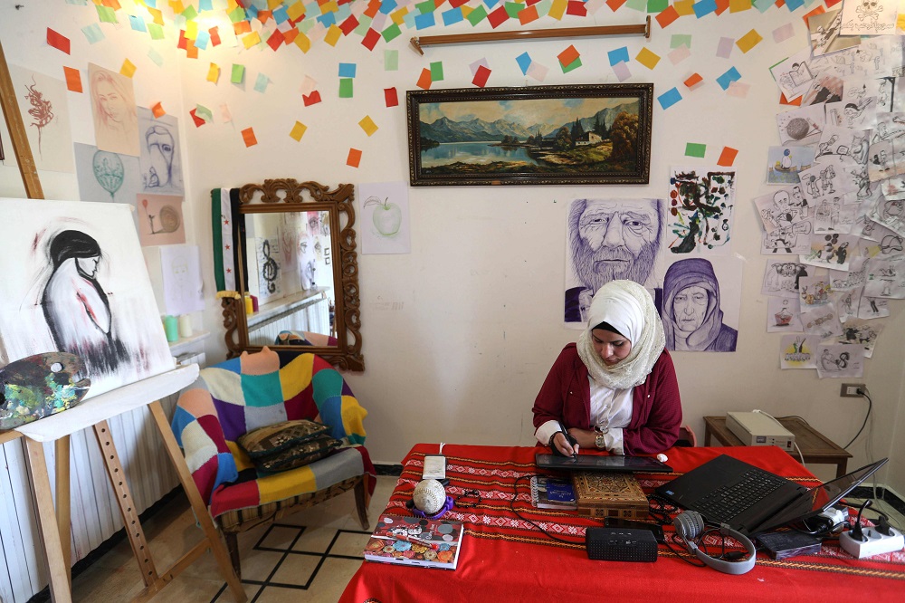 Syrian cartoonist Amani al-Ali draws an illustration on a digital tablet device in her home studio in the city of Idlib in the eponymous northwestern province June 16, 2019. u00e2u20acu201d AFP pic
