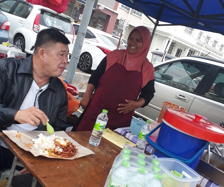 Kuan Chee Heng (left) visits Mareeyau00e2u20acu2122s stall at the Shell Station along the South Klang Valley Expressway. u00e2u20acu201d Picture via Facebook/kuan.cheeheng