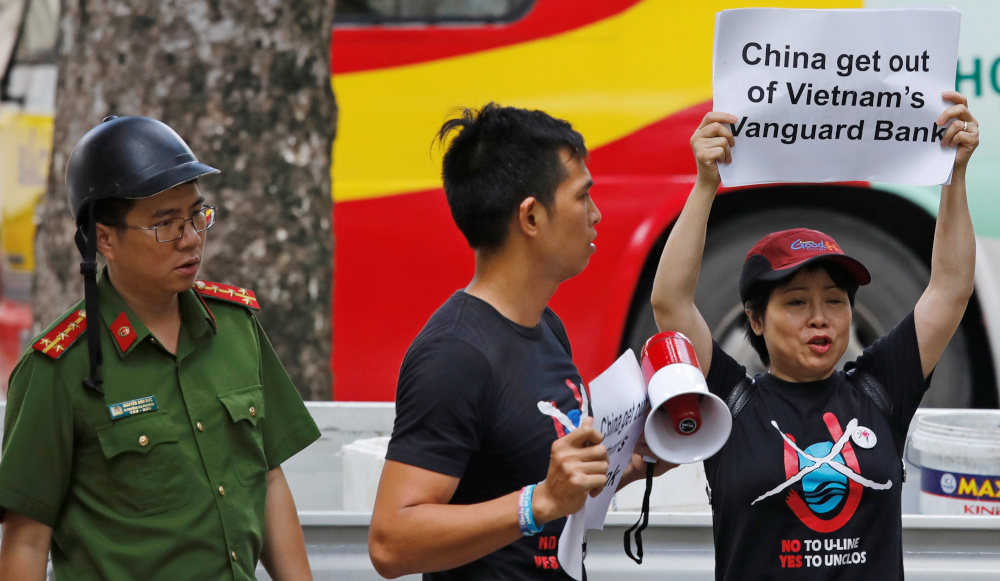 A Vietnamese policeman approaches anti-China protesters as they hold placards during a demonstration in front of the Chinese embassy in Hanoi, Vietnam August 6, 2019. u00e2u20acu201d Reuters pic 