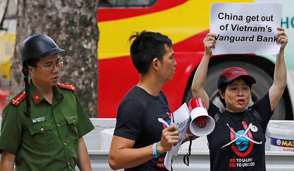 A Vietnamese policeman approaches anti-China protesters as they hold placards during a demonstration in front of the Chinese embassy in Hanoi August 6, 2019. u00e2u20acu201d Reuters pic
