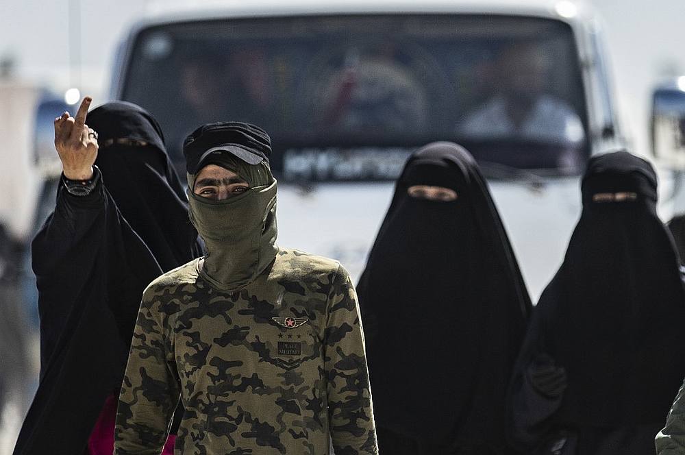 An internal security patrol member escorts women, reportedly wives of Islamic State (IS) group fighters, in the al-Hol camp in al-Hasakeh governorate in northeastern Syria July 23, 2019. u00e2u20acu201d AFP pic