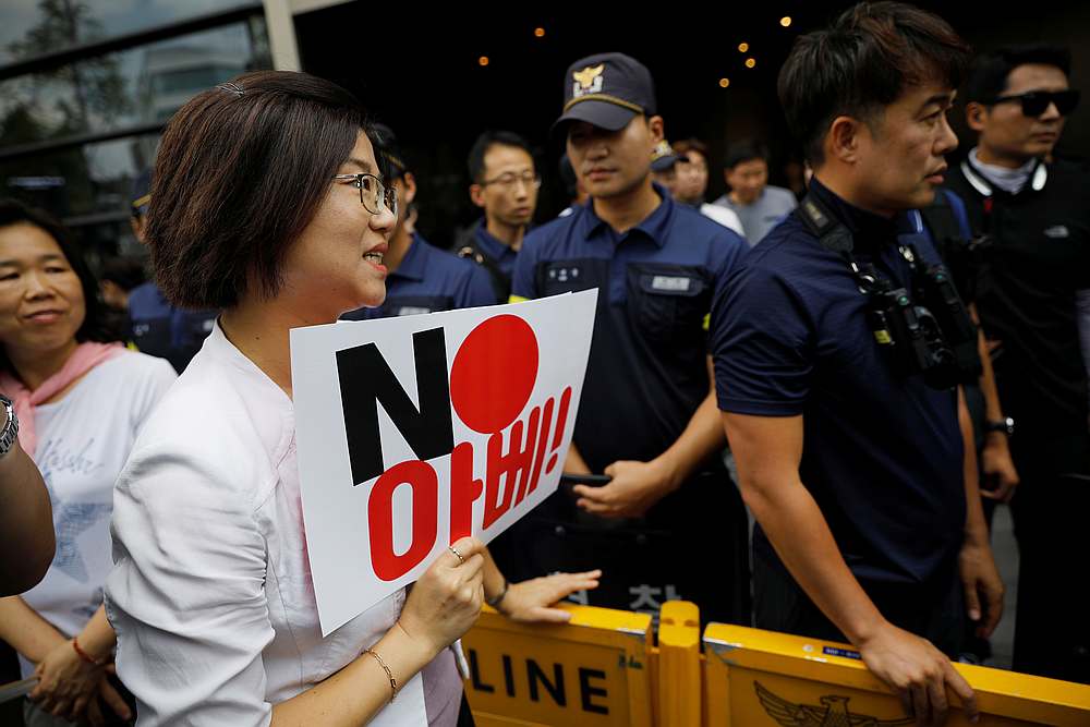 A protester holding a sign argues with policemen during an anti-Japan rally in front of the Japanese embassy in Seoul, South Korea, August 2, 2019. The sign reads 'NO Abe.' u00e2u20acu201d Reuters pic