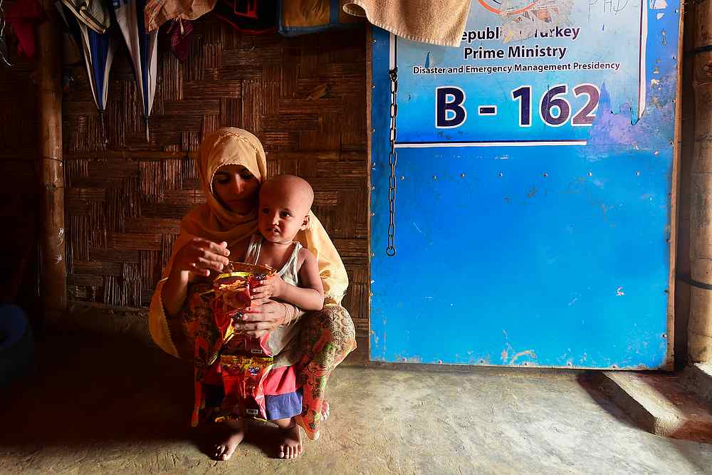 Rohingya refugee Rashida Khatun interacts with her son Ahmad Shah, who was born two years ago, at their makeshift home in Balukhali refugee camp August 25, 2019. u00e2u20acu201d AFP pic