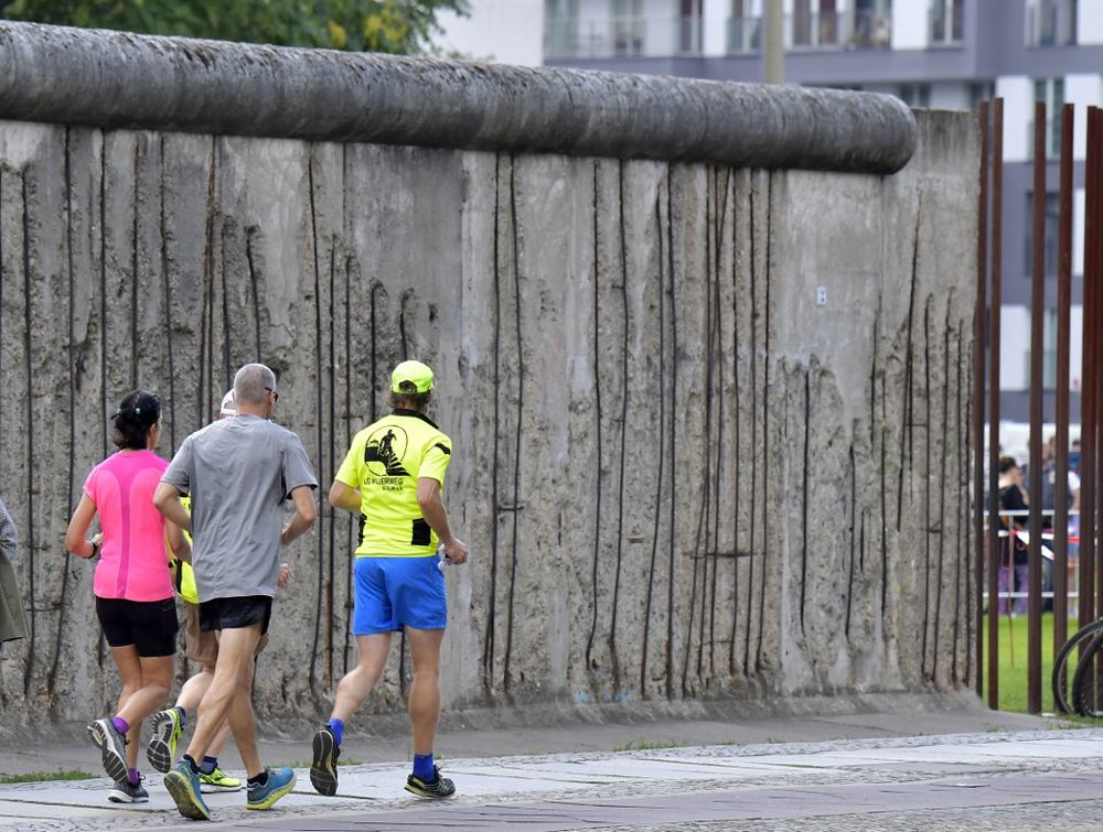 Participants of the so-called Friendship-Run run past a remaining section of the Berlin Wall on the eve of the 8th edition of the Berlin Wall Race on August 16, 2019. u00e2u20acu201d AFP pic