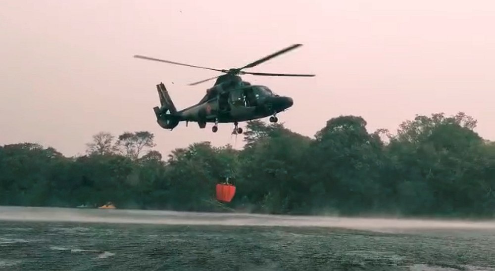 A Bolivian Air Force helicopter collects water to fight forest fire, near Robore August 19, 2019. u00e2u20acu201d Social media video image/Jerjes Suarez Ruiz via Reuters