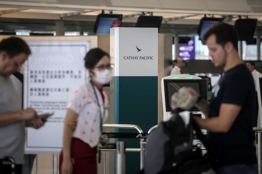 A staff member helps passengers in the Cathay Pacific Airways check-in area at Hong Kongu00e2u20acu2122s International Airport on August 10, 2019. Hong Kong pro-democracy activists kept up the pressure on authorities with a sit-in at the cityu00e2u20acu2122s airport. u00e2u20acu201d AFP pic