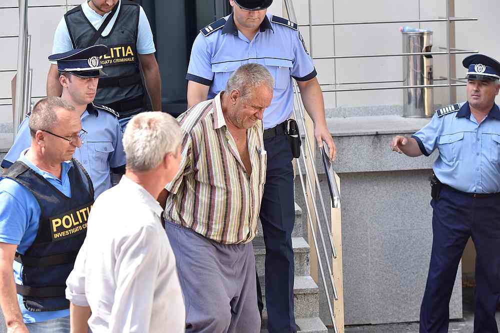 Gheorghe Dinca, 65, is escorted outside the court house in Craiova, Romania, July 27, 2019. u00e2u20acu201d Inquam Photos/Bogdan Danescu via Reuters