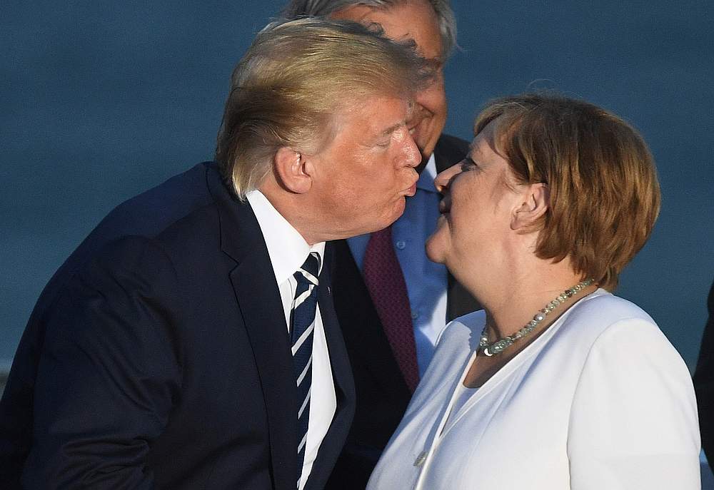 US President Donald Trump kisses German Chancellor Angela Merkel during a family photo opportunity at the G7 summit in Biarritz, France August 25, 2019. u00e2u20acu201d Andrew Parsons/Pool pic via Reuters