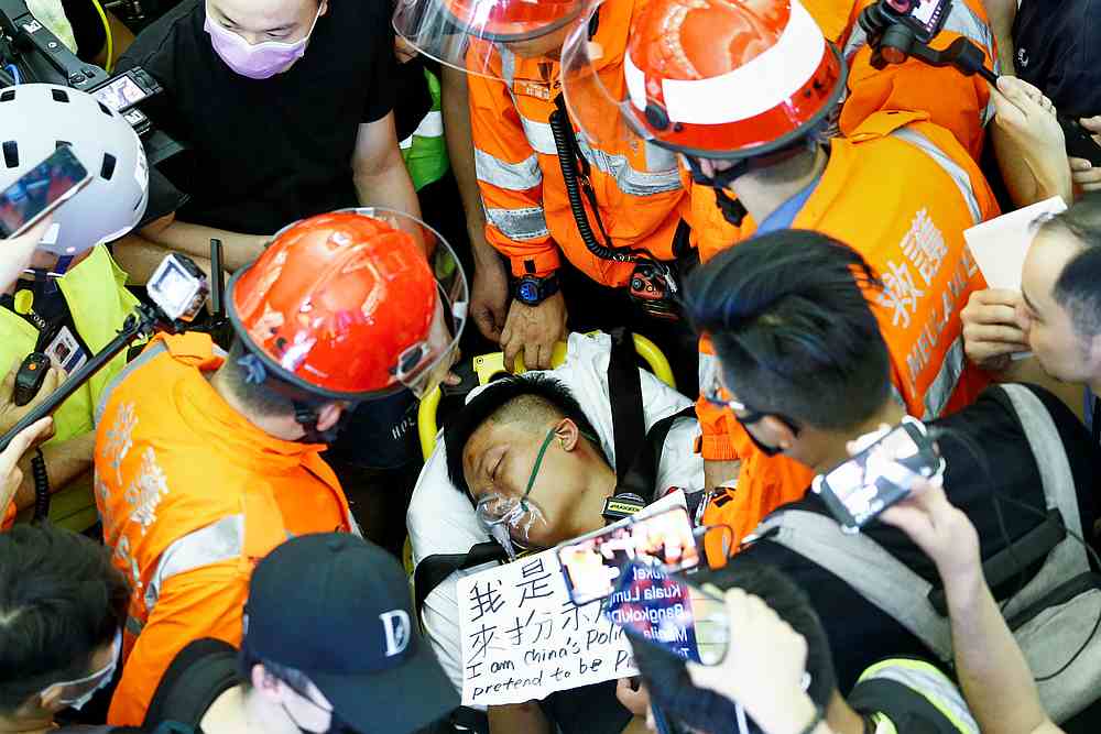 Medics attempt to remove an injured man, who some anti-government protesters said was an undercover police officer from mainland China, at the airport in Hong Kong August 13, 2019. u00e2u20acu201d Reuters pic
