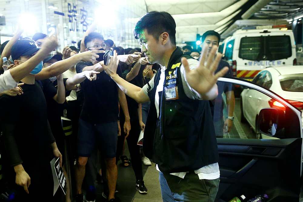 Anti-government protesters gesture at police during clashes at the airport in Hong Kong, China August 13, 2019. — Reuters pic