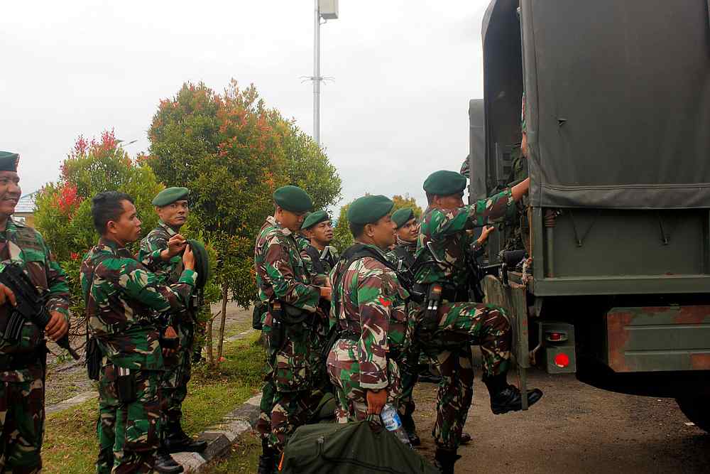 Indonesian soldiers get on to the vehicle as they arrive at Domine Eduard Osok Airport to be deployed to Sorong and Manokwari, West Papua August 20, 2019. u00e2u20acu201d Antara Foto/Olha Mulalinda pic via Reuters