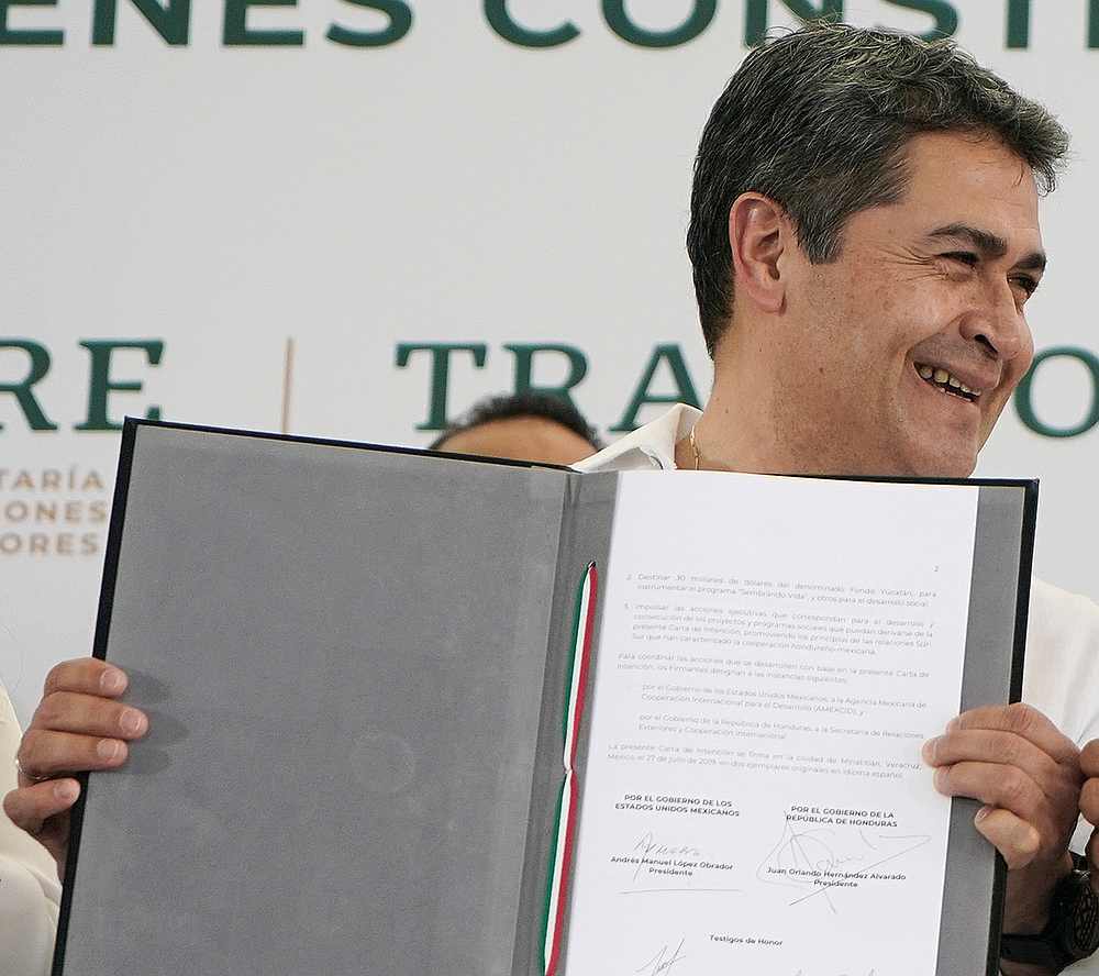Honduran President Juan Orlando Hernandez show a cooperation with Mexixo document in Minatitlan, Veracruz, Mexico July 27, 2019. u00e2u20acu201d Press Office Andres Manuel Lopez Obrador handout via Reuters