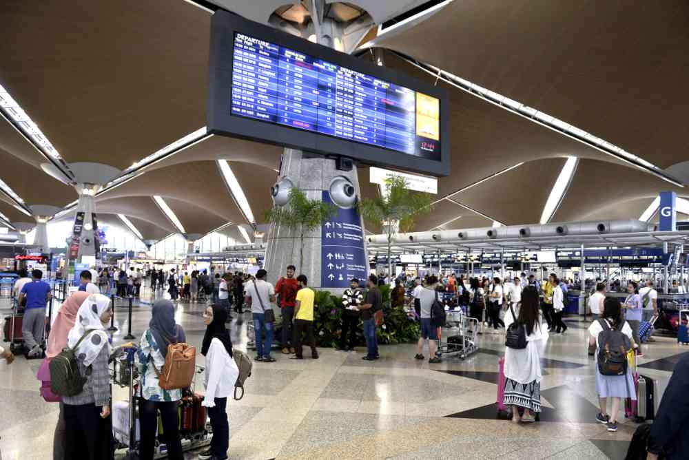 Travellers queue up to check-in for their flights at the Kuala Lumpur International Airport in Sepang August 24, 2019. u00e2u20acu2022 Picture by Miera Zulyana