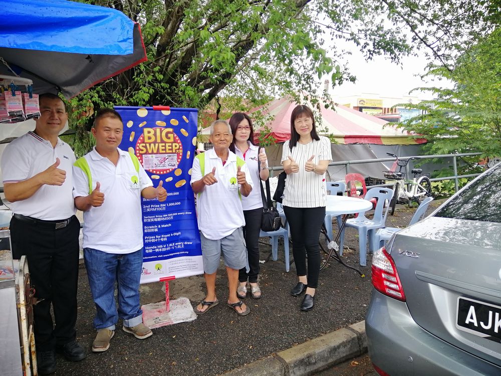 Phen Kin Chuen (second left) sold a winning ticket that netted him a commission. It will go a long way in helping his cancer-stricken mother. u00e2u20acu201d Picture by Sylvia Looi